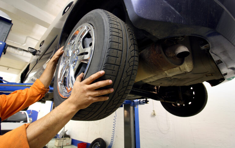 tech changing a tire on a car